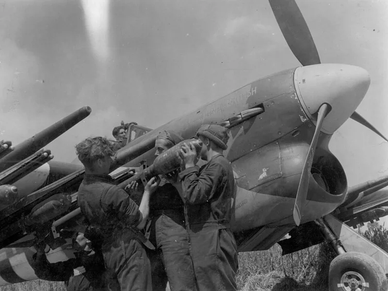 A Royal Air Force (RAF) Hawker Typhoon being re-armed in July 1944 on a forward airfield in France during Operation Overlord,