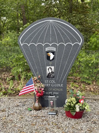The parachute-shaped stone memorial to Lieutenant Colonel Robert Cole at the edge of a field in Best, the Netherlands.