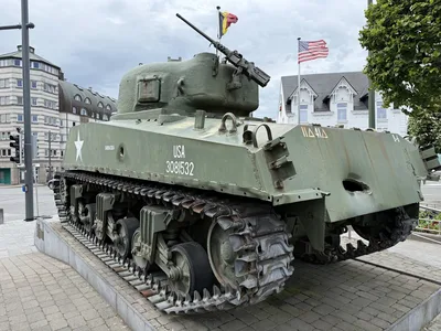 Barracuda Sherman tank on McAuliffe Square, Bastogne, showing the 75mm shell hole in the left side and the Panzerfaust hole in the rear.
