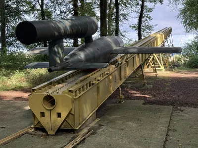 Replica V1 flying bomb on its launch ramp at Site Nr 161 in the forest of Eu at Guerville, the ramp rising away through the trees