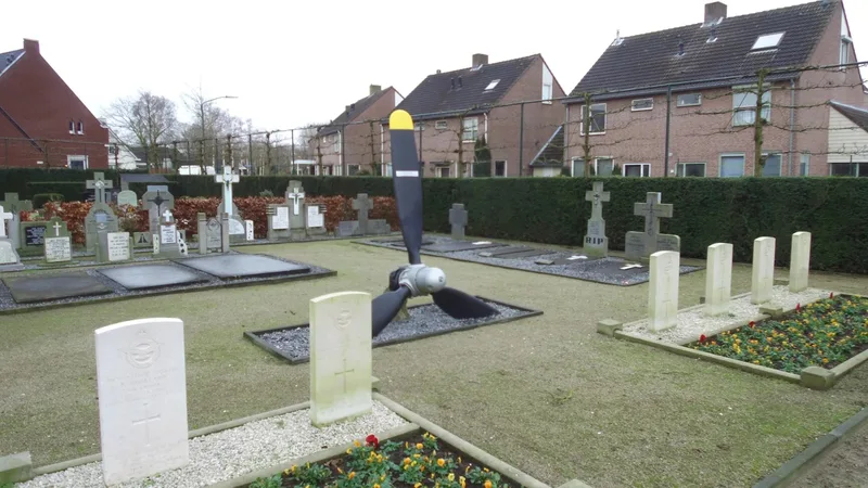 The Sonya's propeller in the cemetery at Erp, with the white headstones of British servicemen in front of and beside it