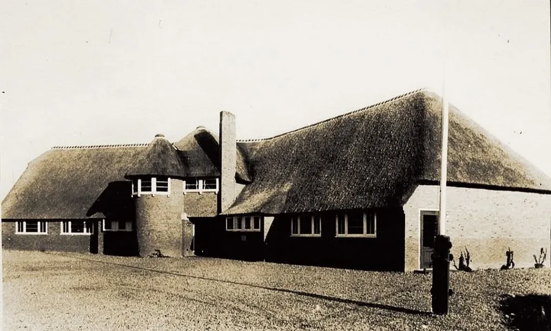 The ULO school on Kneppelhoutweg in Oosterbeek before the war, a long brick building under a thatched roof with a round tower at one end.